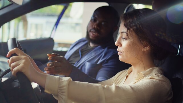 Customers doing pre purchase inspection of car in showroom parking lot, looking for possible faults. Clients experiencing driving conditions in new vehicle before making investment, camera B - Powered by Adobe