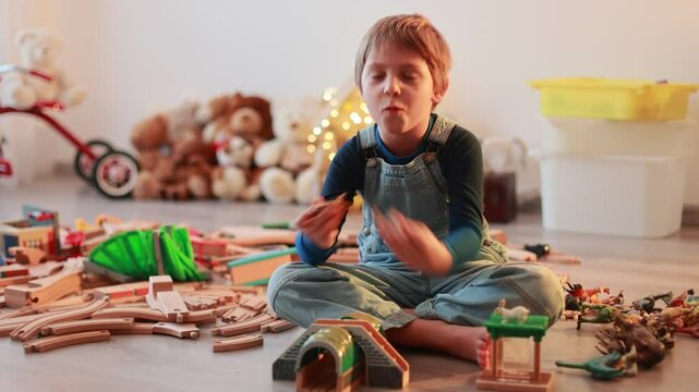 Child, cute boy, playing with toys in a playroom, focus on his feet