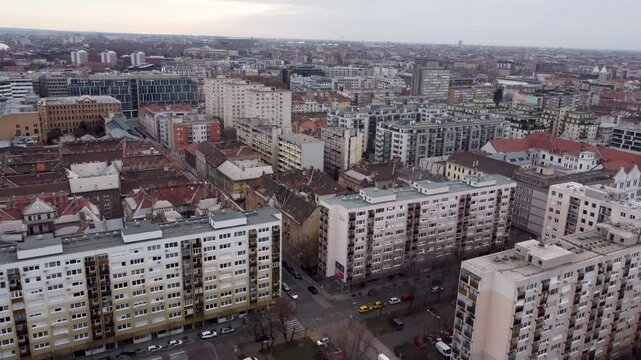 Aerial of brutalist-style residential blocks, both older and newer, in Budapest, revealing tidy layouts and scattered trees