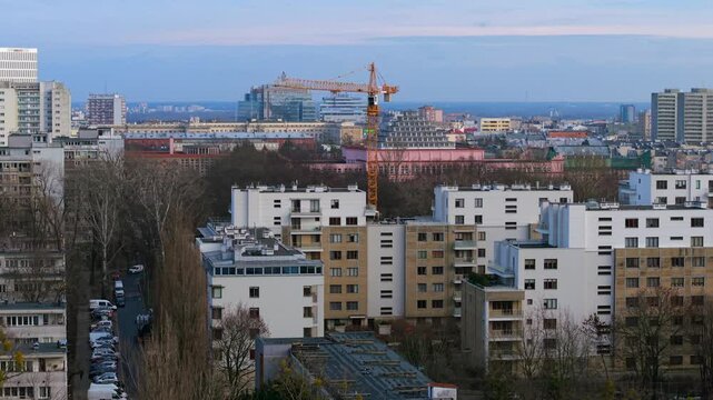 Drone circles around industrial tower crane for highrise building construction in urban residential neighbourhood of Mokotow district in Warsaw