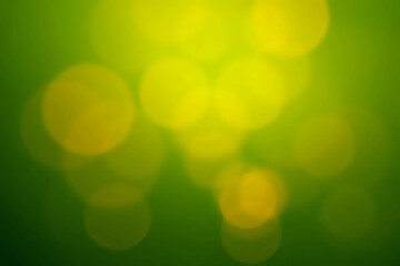 Obraz premium Green, yellow, orange background made in the camera with a macro lens creating out of focus circles of light and bokeh with soft outlines perfect for copy space or text.