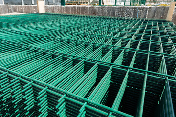 Obraz premium Close-up top view of factory packaging with metal lattice fencing modules with green rectangular cells on a wooden shipping pallet