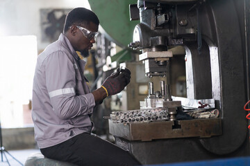 Male engineer repairing and maintenance heavy lathe machine in industry factory. Male technician worker checking parts of lathe machine at workshop