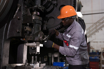 Male engineer repairing and maintenance heavy lathe machine in industry factory. Male technician worker checking parts of lathe machine at workshop