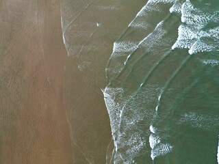 Aerial view of waves on a sandy beach at 90 Mile Beach, New Zealand