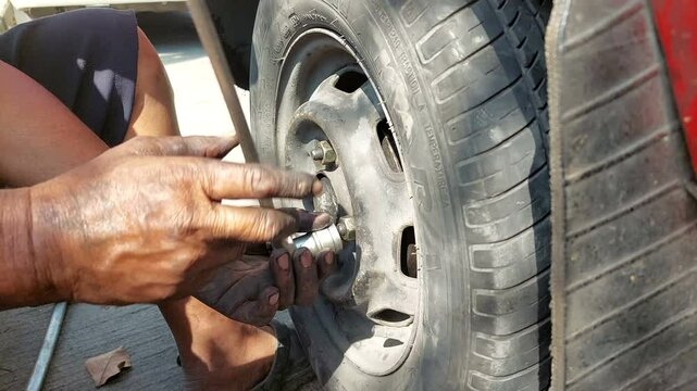 Mechanic turning car wheel nuts