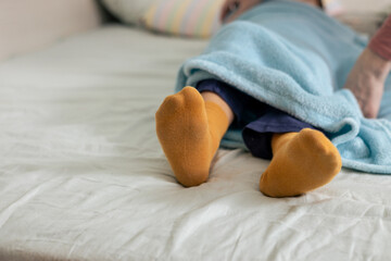 Mom taking care of her child, wrapping him in a soft blue blanket before sleeping