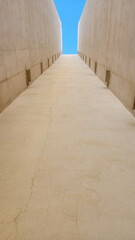 road running through concrete walls and blue sky on the horizon