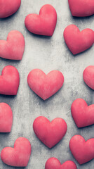 Obraz premium Pink heart shaped objects arranged on textured gray background, creating romantic and artistic pattern