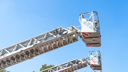 A pair of fire trucks with a ladder on top of them. The ladder is attached to the side of the truck © Антон Скрипачев