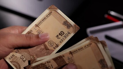 Sion, Maharashtra, India-June 5th-2024-Close static shot of counting Indian 10 rupee notes with naked hands.