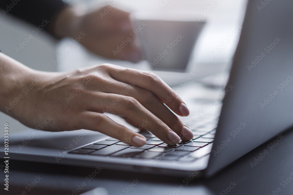 Poster female hands in sharp focus typing on a modern laptop keyboard, office environment in soft blur behi