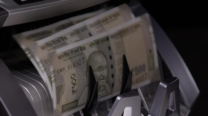 Close shot of Indian five hundred rupee notes coming out of the counting machine.