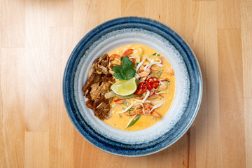 asian style lunch dish of protein tempeh chicken vegetable sauce rice side dish fresh lime garnish