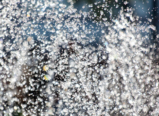 A large amount of water droplets falling from the sky, creating a misty