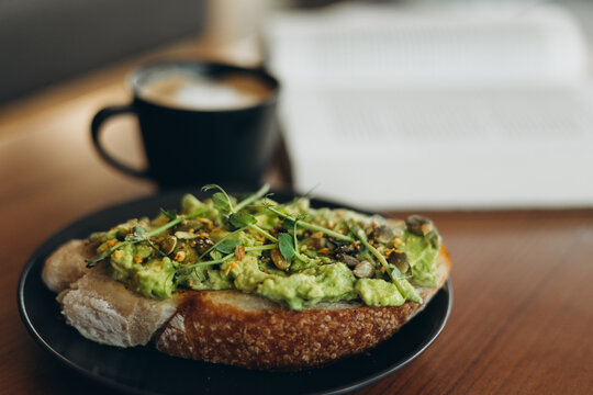 Fresh avocado toast and coffee on a cozy wooden table