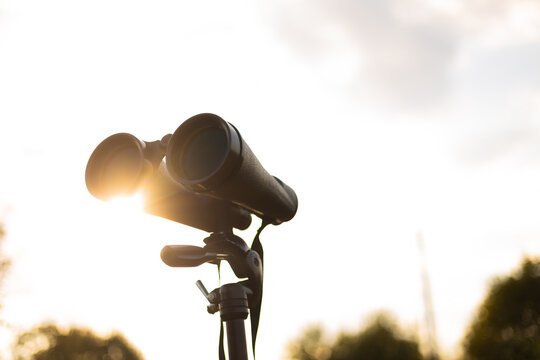 Binoculars on Tripod with Sunlight Gleaming in Nature