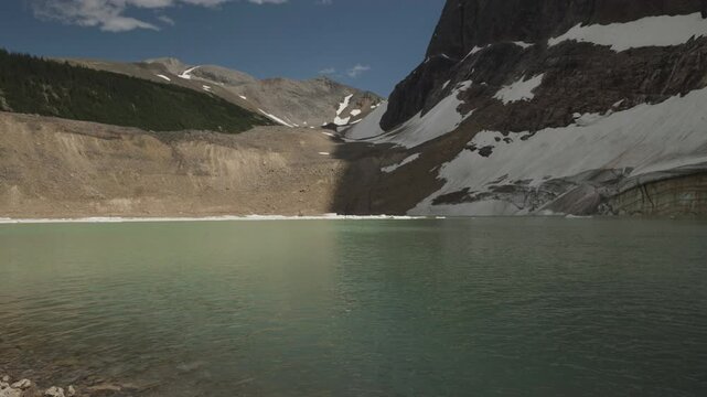 A serene glacial lake with snowy peaks in Mount Edith Cavell, Canadian Rockies