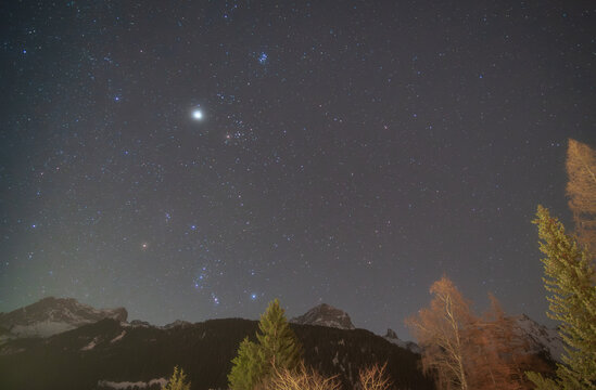 Orion, Taurus, Jupiter, Sirius, and the Pleiades above alpine peaks