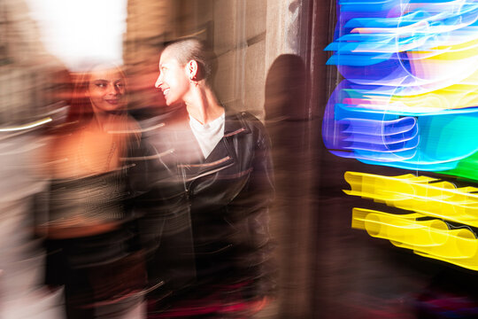 Vibrant city nightwalk with a happy lesbian couple in colorful lights