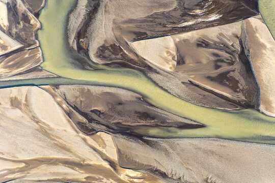 Aerial view of golden rivers meandering through sandy terrain in Iceland