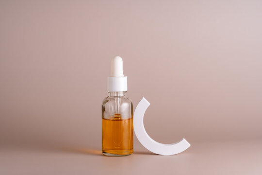 Cosmetic oil bottle with modern design on beige background