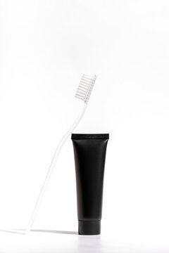 Minimalist black toothpaste tube with white toothbrush