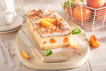 Sweet peach cheesecake served on bright kitchen.