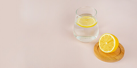 Morning routine: a glass of water with lemon and lemon on a light background. Concept of proper nutrition, vitamins and a healthy lifestyle, refreshing and refreshing drinks. Cold season, soft focus