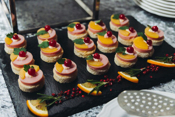 Catering table, beautifully decorated banquet with variety different food snacks appetizers on christmas corporate birthday party event or wedding celebration, canape, salad, delicatessen setting