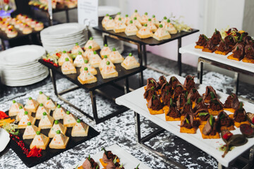 Catering table, beautifully decorated banquet with variety different food snacks appetizers on christmas corporate birthday party event or wedding celebration, canape, salad, delicatessen setting