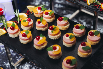 Catering table, beautifully decorated banquet with variety different food snacks appetizers on christmas corporate birthday party event or wedding celebration, canape, salad, delicatessen setting