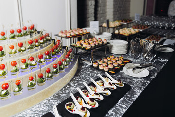 Catering table, beautifully decorated banquet with variety different food snacks appetizers on christmas corporate birthday party event or wedding celebration, canape, salad, delicatessen setting