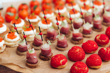 Catering table, beautifully decorated banquet with variety different food snacks appetizers on christmas corporate birthday party event or wedding celebration, canape, salad, delicatessen setting