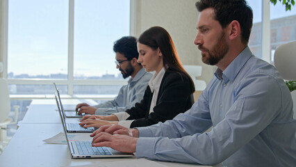 Moving shot row of multiethnic business people typing laptop pressing buttons on computer in modern...