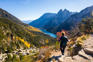 Fototapeta premium Young hiker woman in autumn in Aiguestortes and Sant Maurici National Park, Spain
