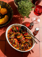  ratatouille, featuring sliced zucchini, eggplant, tomatoes, and yellow peppers garnished with...