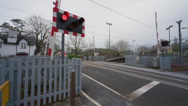 BARLASTON, STAFFORDSHIRE, ENGLAND - JANUARY 8 2025: DPD courier van passing over a level crossing just before the barriers close.
