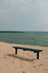 Obraz premium green bench on the lake shore