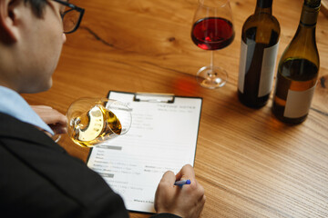 Sommelier Holding Wine Glass and Making Notes to Blank