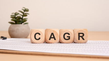 wooden blocks with rounded edges spell out the acronym CAGR, white background
