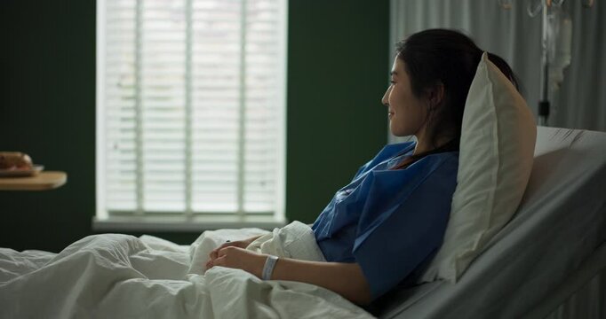 Young woman rests in a hospital bed. An African doctor brings her breakfast on a tray.