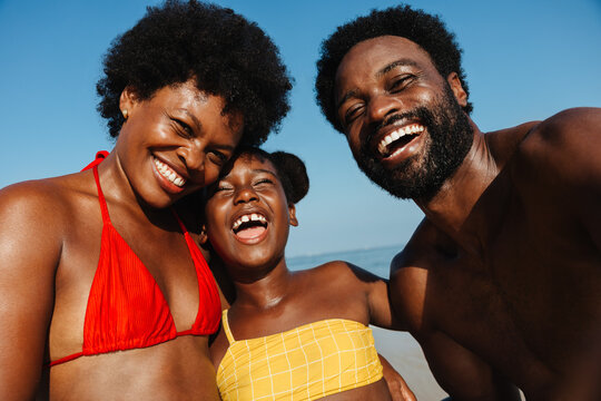Happy family taking a selfie together at the beach