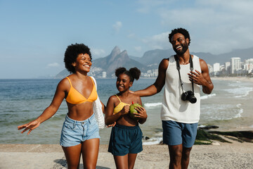 Happy family walking along Ipanema beach in Rio de Janeiro