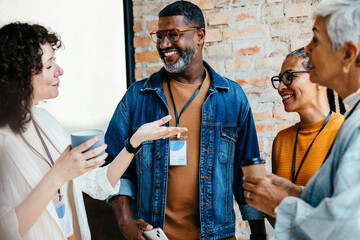 Friendly business colleagues enjoying a casual coffee break while engaging in positive conversation and networking