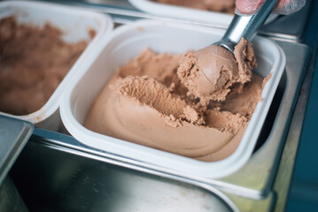 The seller puts a ball of ice-creamby scoop