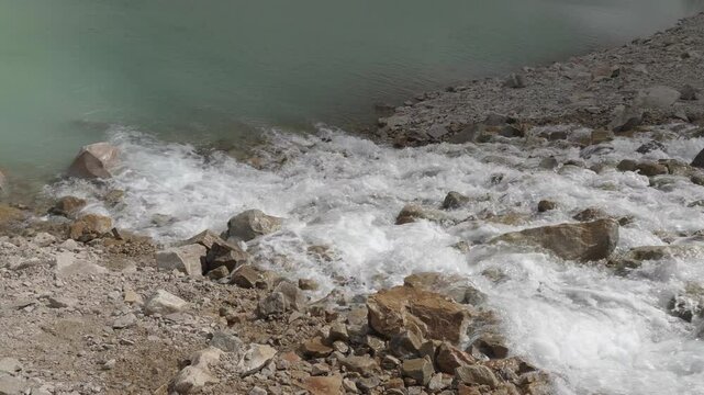 A serene mountain stream flows over rocky terrain near Mount Edith Cavell