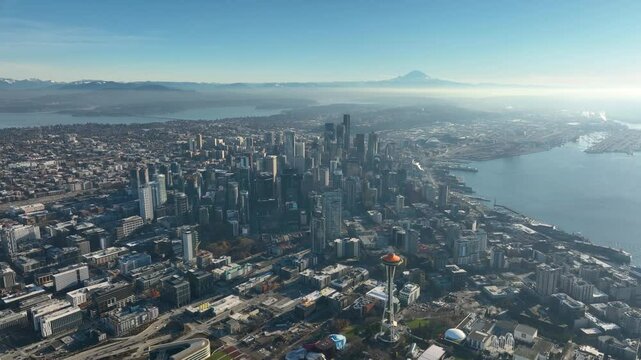 High altitude aerial of Seattle cityscape, Elliot Bay, Mt Rainer with blue sky