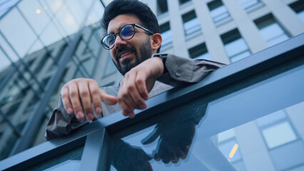 Arabian Indian man upset sad businessman sorrowful business employer on city balcony outside...