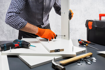 Handyman assembling new furniture. Close-up. Selective focus.